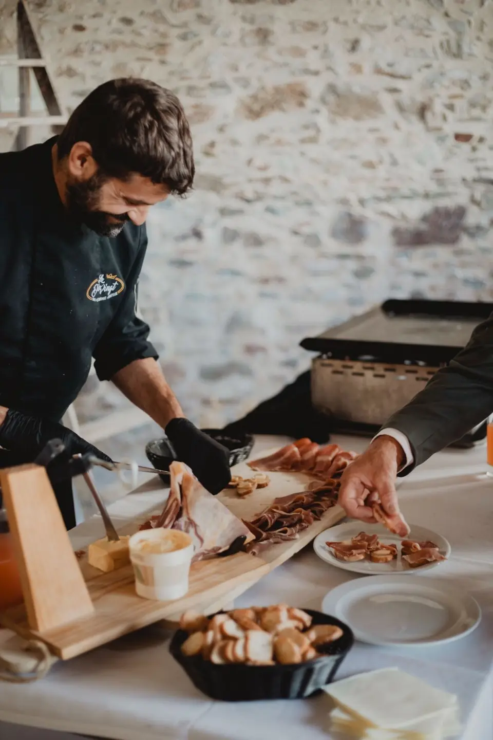 Le Chef découpe le jambon au couteau, sourire aux lèvres